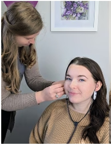 Elevate Audiology clinician adjusting a hearing aid behind a patient's ear