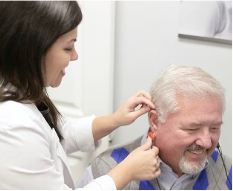 Dr. Tarvin fitting a hearing aid for a patient at Elevate Audiology