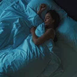 Woman sleeping peacefully in her bed at night.